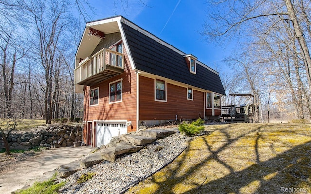 12109 Shaffer Rd, Davisburg, MI 48350 - view of side of property with an attached garage, concrete driveway, a deck, a gambrel roof, and a balcony