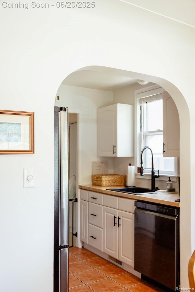 632 S Edison Ave, Royal Oak, MI 48067 - kitchen featuring dishwashing machine, arched walkways, freestanding refrigerator, and white cabinets