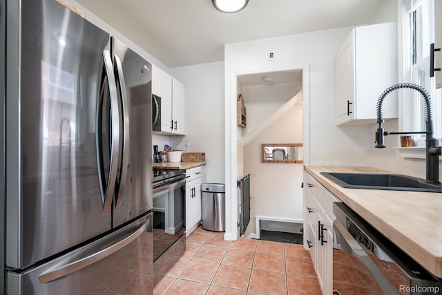 632 S Edison Ave, Royal Oak, MI 48067 - kitchen with appliances with stainless steel finishes, white cabinetry, and light tile patterned floors