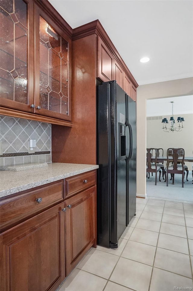 2942 Bywater Dr, Troy, MI 48085 - kitchen featuring black fridge with ice dispenser, glass insert cabinets, decorative backsplash, light tile patterned flooring, and light stone countertops