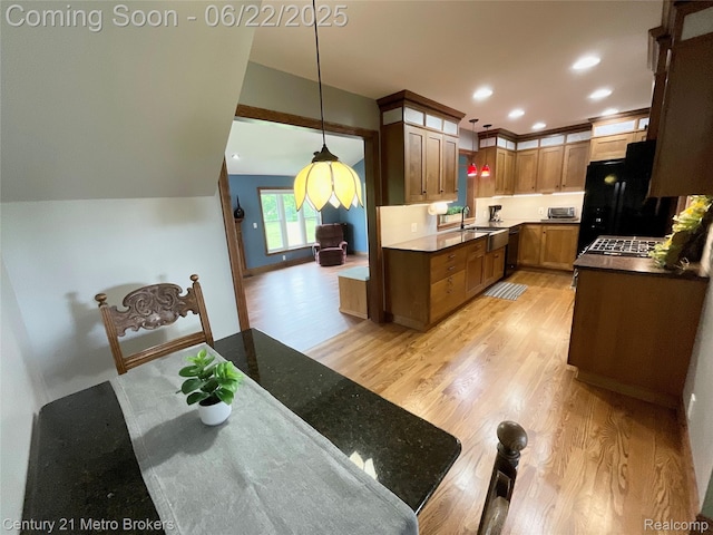 7094 Reid Rd, Swartz Creek, MI 48473 - kitchen with light wood-style flooring, freestanding refrigerator, dishwasher, hanging light fixtures, and dark countertops