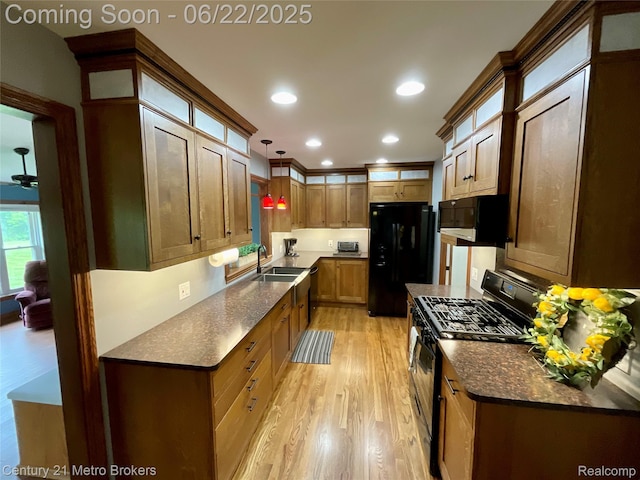 7094 Reid Rd, Swartz Creek, MI 48473 - kitchen with black appliances, light wood-type flooring, dark stone counters, hanging light fixtures, and recessed lighting