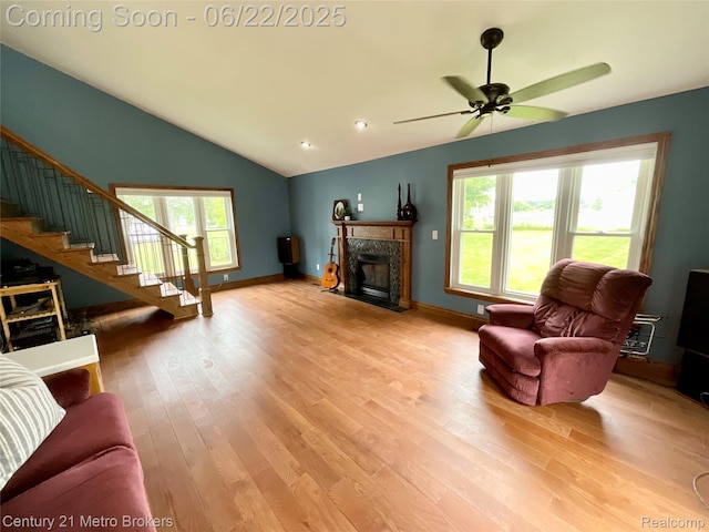 7094 Reid Rd, Swartz Creek, MI 48473 - living area featuring light wood-style flooring, vaulted ceiling, a high end fireplace, ceiling fan, and stairway