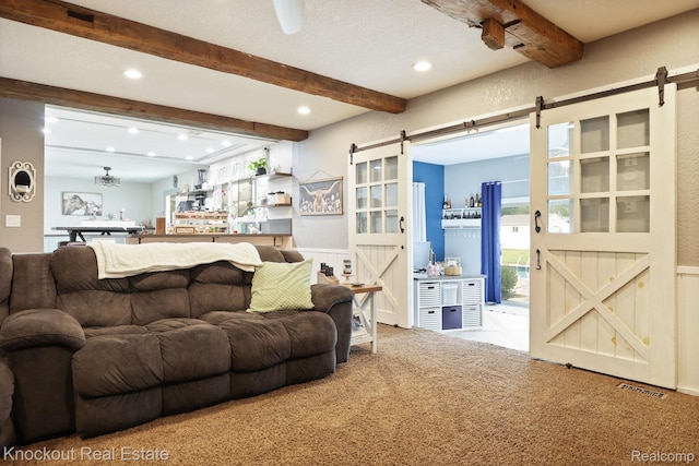 605 Shawnesee, Flushing, MI 48433 - living area with a barn door, beam ceiling, carpet flooring, recessed lighting, and a wainscoted wall