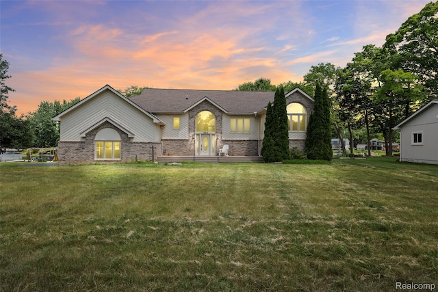 969 Bogie Lake Rd, White Lake, MI 48383 - view of front of house with brick siding, a yard, and roof with shingles