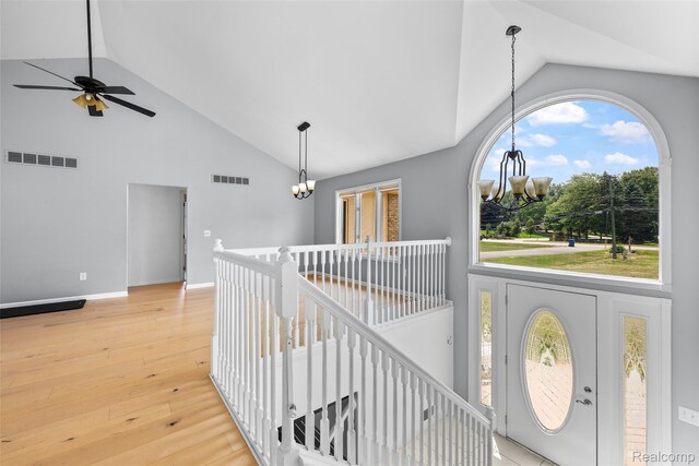 969 Bogie Lake Rd, White Lake, MI 48383 - corridor with a chandelier, high vaulted ceiling, an upstairs landing, and light wood-style floors