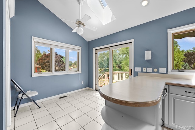 969 Bogie Lake Rd, White Lake, MI 48383 - dining area featuring healthy amount of natural light, a skylight, ceiling fan, lofted ceiling, and light tile patterned floors
