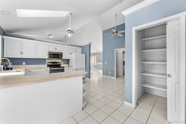 969 Bogie Lake Rd, White Lake, MI 48383 - kitchen featuring range with electric cooktop, stainless steel microwave, ceiling fan, freestanding refrigerator, and light tile patterned floors