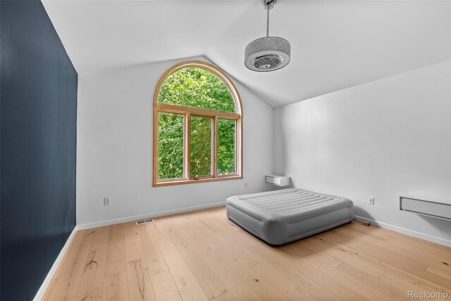 969 Bogie Lake Rd, White Lake, MI 48383 - unfurnished bedroom with vaulted ceiling and hardwood / wood-style flooring