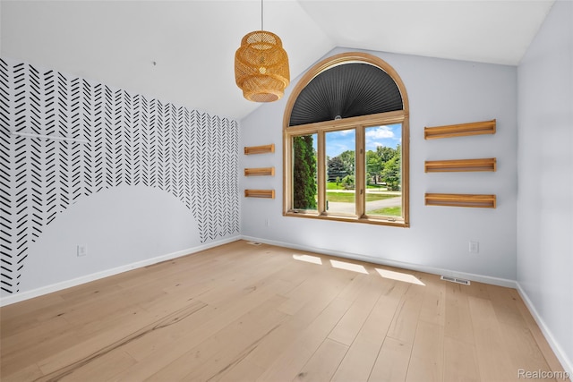 969 Bogie Lake Rd, White Lake, MI 48383 - spare room featuring light wood-style floors, lofted ceiling, and an accent wall