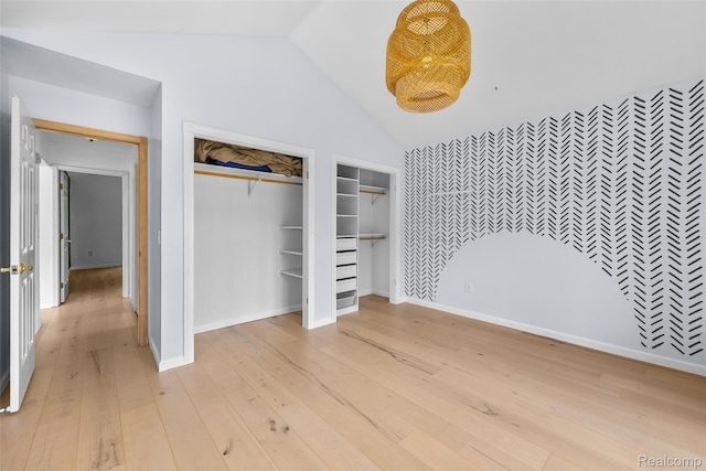 969 Bogie Lake Rd, White Lake, MI 48383 - unfurnished bedroom featuring light wood-style floors, lofted ceiling, and two closets