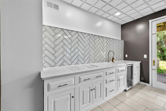 969 Bogie Lake Rd, White Lake, MI 48383 - kitchen featuring wine cooler, white electric stovetop, light countertops, and white cabinetry