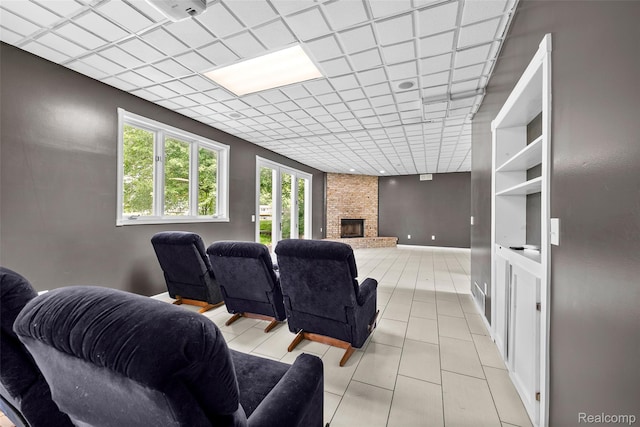 969 Bogie Lake Rd, White Lake, MI 48383 - home theater room with light tile patterned floors, a large fireplace, and a paneled ceiling