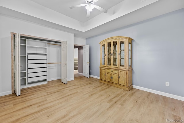 969 Bogie Lake Rd, White Lake, MI 48383 - unfurnished bedroom with light wood-type flooring, a closet, ceiling fan, and a tray ceiling
