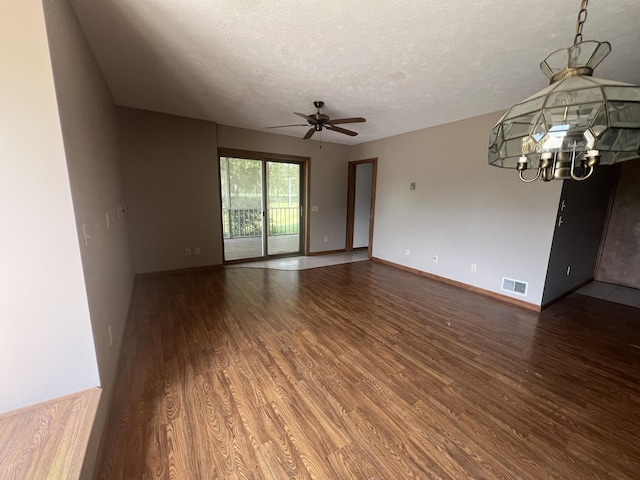 7567 S Bignham Ave, Newaygo, MI 49337 - empty room with wood finished floors, a textured ceiling, a ceiling fan, and a chandelier
