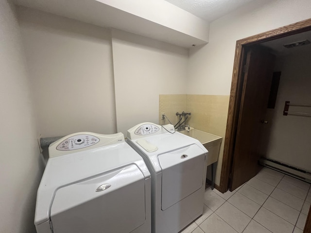 7567 S Bignham Ave, Newaygo, MI 49337 - laundry area with light tile patterned floors, washing machine and dryer, and a baseboard heating unit