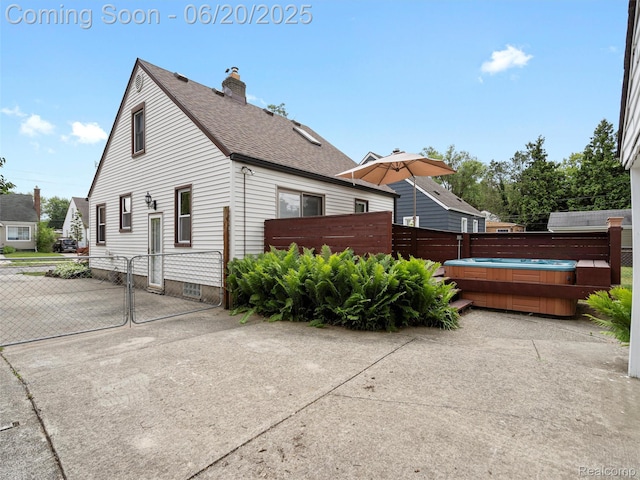 3299 Goodrich St, Ferndale, MI 48220 - view of side of home with a hot tub, a shingled roof, a chimney, a patio, and a gate