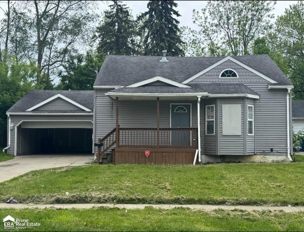 2449 Gibson St, Flint, MI 48503 - view of front facade with covered porch, an attached garage, concrete driveway, a front yard, and roof with shingles