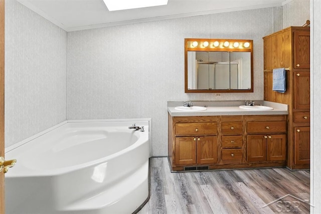 3227 S 11 Mile Rd, Auburn, MI 48611 - bathroom featuring crown molding, wood finished floors, a garden tub, double vanity, and a skylight