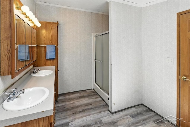 3227 S 11 Mile Rd, Auburn, MI 48611 - full bath with ornamental molding, a shower stall, wood finished floors, and double vanity