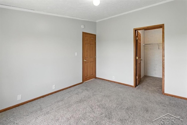 3227 S 11 Mile Rd, Auburn, MI 48611 - unfurnished bedroom featuring a walk in closet, carpet, ornamental molding, a closet, and a textured ceiling