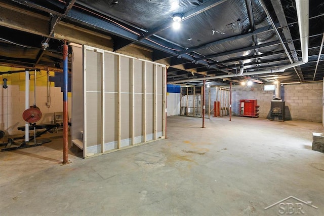 3227 S 11 Mile Rd, Auburn, MI 48611 - unfinished basement featuring a wood stove