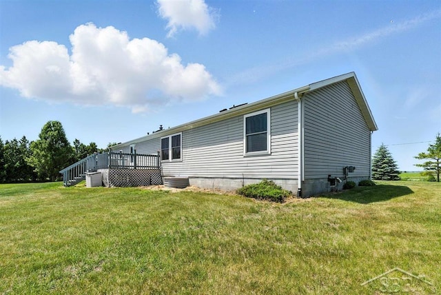3227 S 11 Mile Rd, Auburn, MI 48611 - rear view of house featuring a lawn and a wooden deck