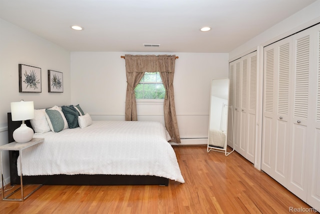 5100 Kings Gate Way, Bloomfield Hills, MI 48302 - bedroom featuring two closets, light wood-style flooring, baseboard heating, and recessed lighting