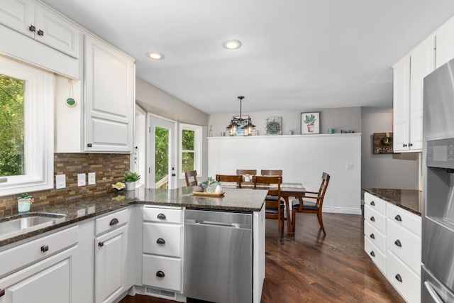 4662 60th St SW, Wyoming, MI 49418 - kitchen featuring appliances with stainless steel finishes, white cabinetry, a peninsula, dark wood-style flooring, and tasteful backsplash