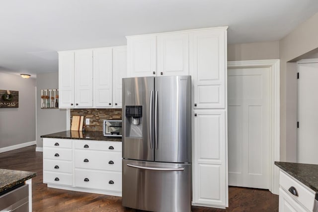 4662 60th St SW, Wyoming, MI 49418 - kitchen featuring stainless steel fridge, decorative backsplash, dark stone countertops, dark wood-type flooring, and white cabinets