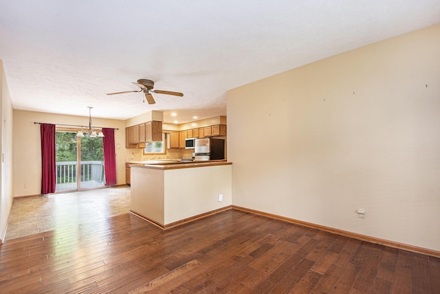 238 Baynton Ave NE, Grand Rapids, MI 49503 - kitchen featuring freestanding refrigerator, ceiling fan, a peninsula, and wood finished floors