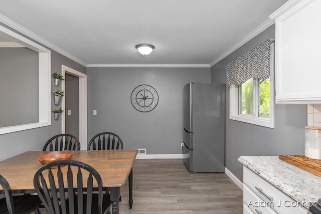 3655 Giddings Ave SE, Grand Rapids, MI 49508 - dining space with light wood-type flooring and crown molding