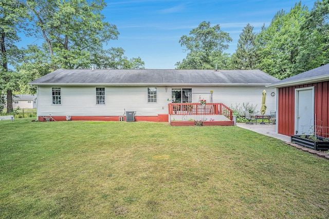 50 S Bock Rd, Muskegon, MI 49442 - rear view of property featuring a lawn, a wooden deck, and an outbuilding