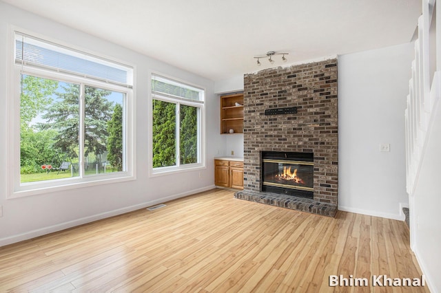 2492 Sunny Creek St SE, Kentwood, MI 49508 - unfurnished living room featuring light wood-style floors and a brick fireplace