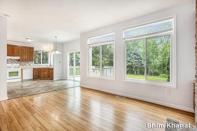 2492 Sunny Creek St SE, Kentwood, MI 49508 - unfurnished living room featuring light wood-style flooring and a chandelier