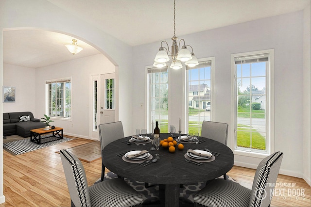 2492 Sunny Creek St SE, Kentwood, MI 49508 - dining area with arched walkways, a chandelier, and light wood-style flooring