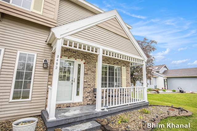 2492 Sunny Creek St SE, Kentwood, MI 49508 - doorway to property with covered porch, brick siding, and a yard