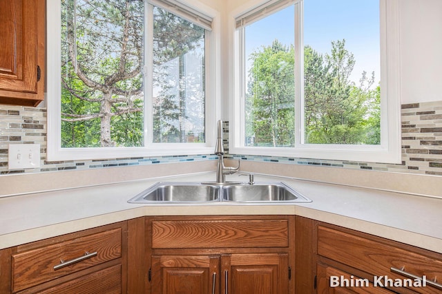 2492 Sunny Creek St SE, Kentwood, MI 49508 - kitchen featuring light countertops, tasteful backsplash, brown cabinetry, and plenty of natural light