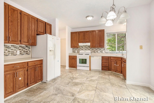 2492 Sunny Creek St SE, Kentwood, MI 49508 - kitchen featuring white appliances, under cabinet range hood, decorative backsplash, a chandelier, and brown cabinets