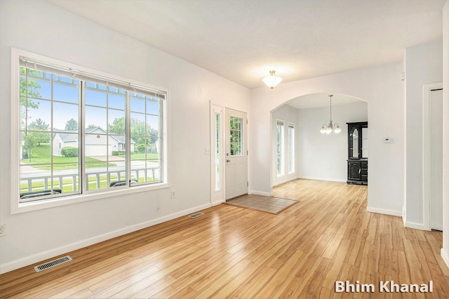 2492 Sunny Creek St SE, Kentwood, MI 49508 - entryway with light wood-style floors, healthy amount of natural light, arched walkways, and a chandelier