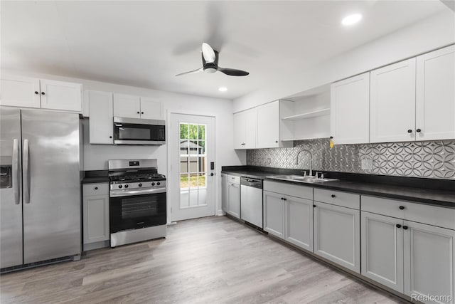3166 Highland Blvd, Highland, MI 48356 - kitchen with stainless steel appliances, dark countertops, open shelves, a ceiling fan, and tasteful backsplash