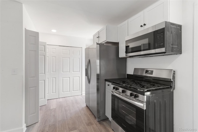 3166 Highland Blvd, Highland, MI 48356 - kitchen with stainless steel appliances, light wood-type flooring, white cabinetry, dark countertops, and recessed lighting