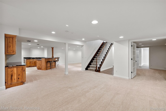 222 Arlington St, Birmingham, MI 48009 - unfurnished living room featuring bar with sink, light colored carpet, stairs, and recessed lighting