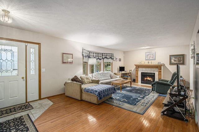 1142 N Peach Ct, Plainwell, MI 49080 - living area featuring a fireplace, a textured ceiling, and light wood-type flooring