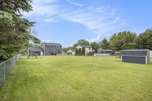 1142 N Peach Ct, Plainwell, MI 49080 - fenced backyard with a playground and a storage unit