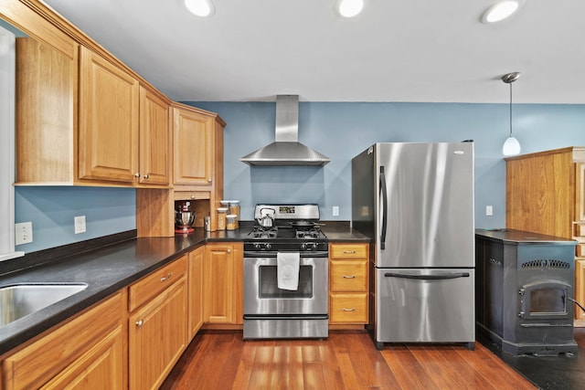14715 Allman Rd, Concord, MI 49237 - kitchen with stainless steel appliances, wall chimney exhaust hood, dark countertops, a wood stove, and dark wood-type flooring