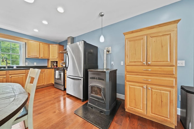 14715 Allman Rd, Concord, MI 49237 - kitchen with stainless steel appliances, wall chimney range hood, a wood stove, recessed lighting, and wood finished floors