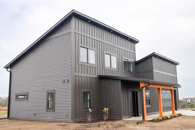2458 Maes Rd, West Branch, MI 48661 - rear view of house featuring a garage and board and batten siding