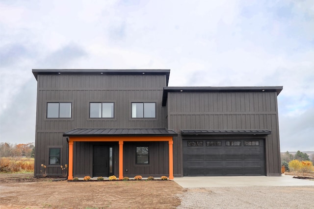 2458 Maes Rd, West Branch, MI 48661 - view of front facade with a standing seam roof, driveway, a metal roof, a garage, and board and batten siding