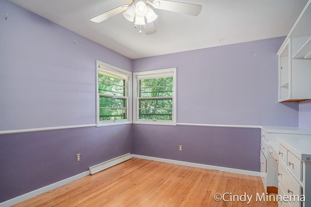 3343 Gateshead St NE, Rockford, MI 49341 - spare room featuring baseboard heating, light wood finished floors, and ceiling fan
